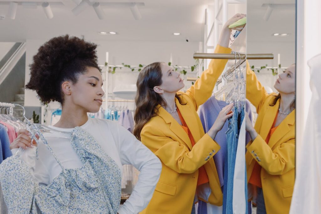 Two women shopping for trendy clothes in a stylish boutique, enjoying a fashionable retail experience.
